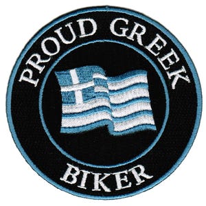 Puede incluir: Un parche bordado en negro y azul con una bandera griega blanca y el texto "Proud Greek Biker".