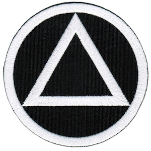 Könnte beinhalten: Ein weißes Dreieck innerhalb eines weißen Kreises auf schwarzem Hintergrund. Das Dreieck ist im Kreis zentriert. Der Kreis ist auf dem schwarzen Hintergrund zentriert.