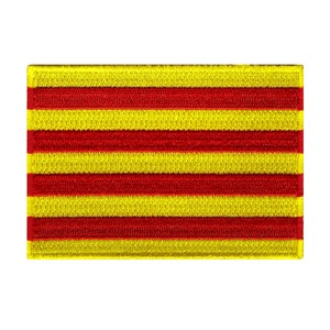 Könnte beinhalten: Ein gelber und roter gestreifter Stoff-Patch mit gewebter Textur. Der Patch ist rechteckig und hat einen weißen Rand.