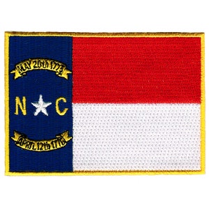 May include: An embroidered patch of the North Carolina state flag. The flag features a blue field with a white star and the letters "N.C." surrounded by a gold ribbon with the text "MAY 20th 1775" and "APRIL 12th 1776". The right side of the flag is red and white.