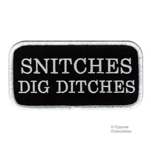 May include: Black and white embroidered patch with the text "Snitches Dig Ditches" in white lettering.