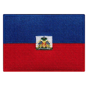 May include: A blue and red embroidered patch featuring the flag of Haiti. The flag has a coat of arms in the center with a palm tree, a cannon, and a drum.