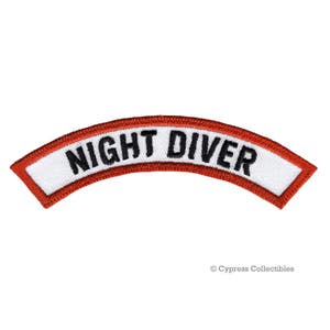 May include: White patch with red trim, curved in a half-circle shape. The patch reads "NIGHT DIVER" in black lettering.