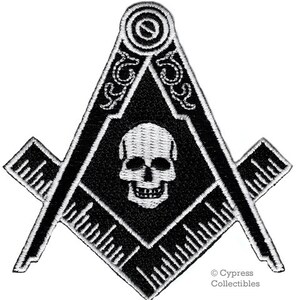 May include: Black and white embroidered patch featuring a skull and crossbones inside a square and compass. The patch has a white outline and is surrounded by a black background. The text "Cypress Collectibles" is in the bottom right corner.