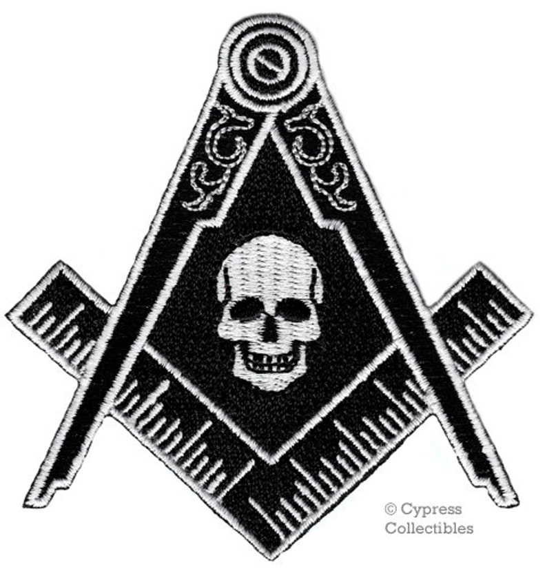 May include: Black and white embroidered patch featuring a skull and crossbones inside a square and compass. The patch has a white outline and is surrounded by a black background. The text "Cypress Collectibles" is in the bottom right corner.