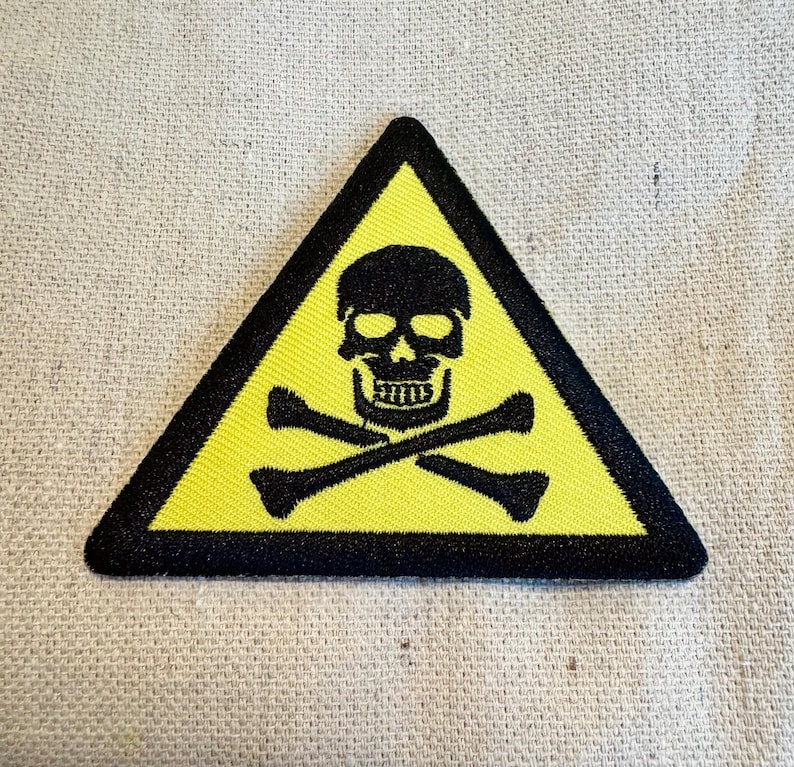 May include: Yellow triangle warning sign with a black skull and crossbones.