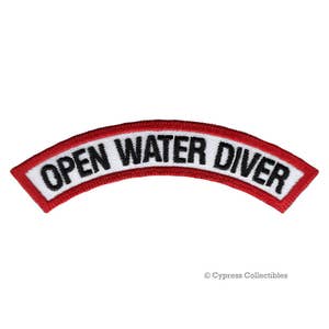 Può includere: Toppa ricamata rossa e bianca con il testo "Open Water Diver" in lettere nere.