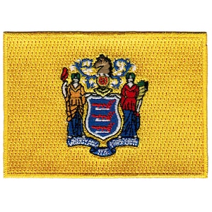 May include: A yellow embroidered patch featuring the state seal of New Jersey. The seal depicts a horse's head, two figures holding a shield with three blue and white stripes, and a banner with the words "Liberty and Prosperity".