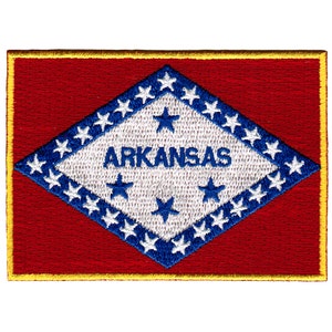 Op de afbeelding: Gestikt patch met de vlag van de staat Arkansas. De vlag is een witte ruit met een blauwe rand en 25 witte sterren op een rode achtergrond. Het woord "ARKANSAS" staat in blauwe letters in de ruit.