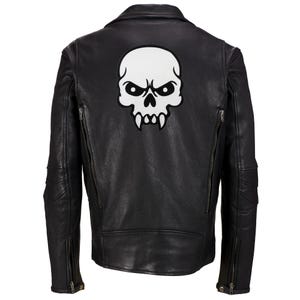 Può includere: Giacca di pelle nera con una toppa di teschio bianco sul retro.