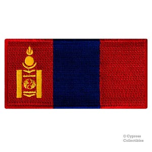 May include: A red, blue, and gold embroidered patch featuring the flag of Mongolia. The flag has a vertical blue stripe in the center, with a red field on either side. The center of the flag features a stylized Soyombo symbol in gold.