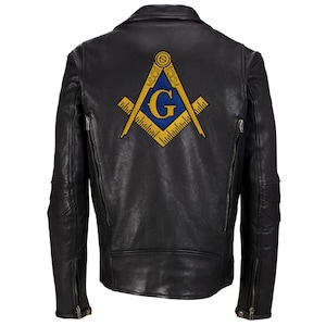 May include: Black leather jacket with a gold and blue Masonic symbol on the back. The symbol features a compass and square with a 'G' in the centre.