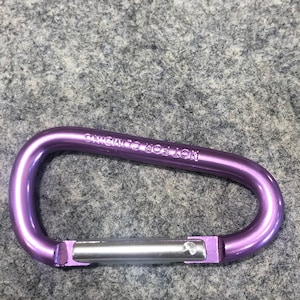May include: Purple metal carabiner with the text "CHICAGO TOOL  LON" engraved on the side.