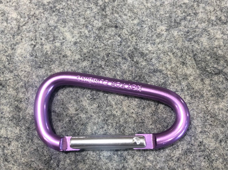 May include: Purple metal carabiner with the text "CHICAGO TOOL  LON" engraved on the side.