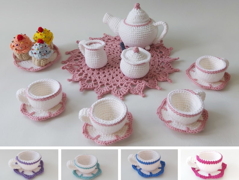 May include: A crocheted tea set with a teapot, creamer, sugar bowl, and four teacups and saucers. The set is white with pink accents and is arranged on a pink crocheted doily.