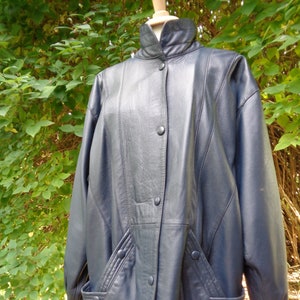 Könnte beinhalten: Eine dunkelblaue Lederjacke mit Stehkragen, Knopfleiste und zwei Pattentaschen.