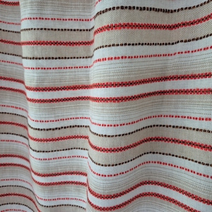 May include: A woven fabric featuring a repeating horizontal striped pattern. The design consists of alternating bands of beige, white, dark brown, and vibrant red threads, creating a textured appearance with a visible grid-like weave structure.