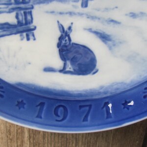 May include: Blue and white ceramic plate with a blue rabbit design and the year 1971 in blue.