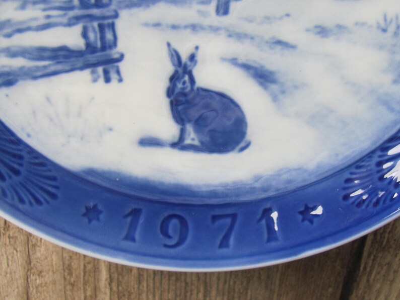 May include: Blue and white ceramic plate with a blue rabbit design and the year 1971 in blue.