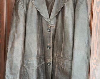 May include: A brown leather jacket with a button closure and two large pockets. The jacket has a worn look and is labeled "KOMO" on the inside.