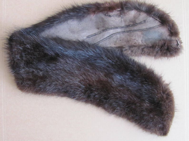 Puede incluir: Un collar de piel marr&oacute;n con una costura cosida en el interior.