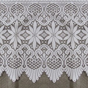 May include: White lace trim with a scalloped edge and intricate floral patterns. The lace has a delicate, feminine look and would be perfect for adding a touch of elegance to any project.