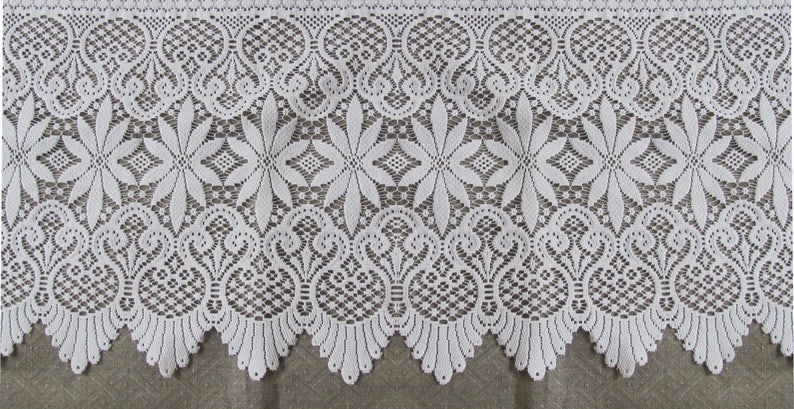 May include: White lace trim with a scalloped edge and intricate floral patterns. The lace has a delicate, feminine look and would be perfect for adding a touch of elegance to any project.