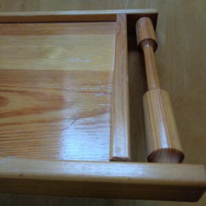 May include: A wooden serving tray with a natural finish and a wooden handle. The tray has a rectangular shape and is made of light-colored wood.