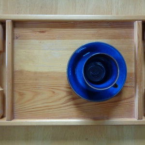 May include: A wooden tray with a blue and gold saucer and cup on top. The tray has a natural wood finish and is made of solid wood.
