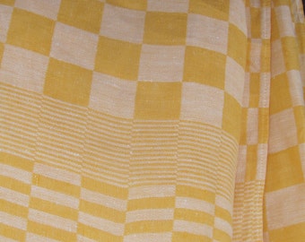 May include: A textile fabric featuring a repeating checkered pattern in shades of yellow and off-white. The material displays a woven texture with alternating blocks of color and horizontal striped bands integrated into the design of the cloth.