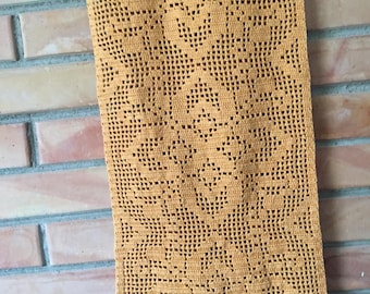 May include: A crocheted table runner in a mustard yellow color with a floral pattern.