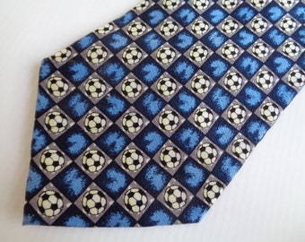 May include: A blue and gray patterned tie with white soccer balls. The pattern is a checkered design with blue and gray squares.