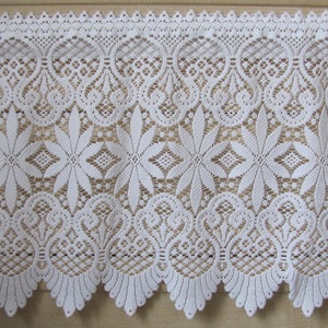 May include: White lace trim with a scalloped edge and a floral pattern. The lace is delicate and intricate, with a repeating design of flowers and leaves.