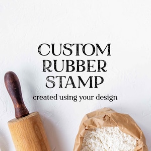 May include: A custom rubber stamp design is featured in this image, with the text "CUSTOM RUBBER STAMP created using your design." A wooden rolling pin and a bag of flour are also visible. The background is white.