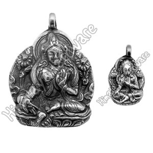 Pode incluir: Pingente de prata com uma representação detalhada de uma figura de Buda sentado. O pingente é talhado de forma intrincada com desenhos florais e uma auréola ao redor da cabeça de Buda.