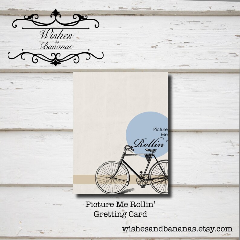 K&ouml;nnte beinhalten: Eine Schwarzwei&szlig;illustration eines Fahrrads mit dem Text "Picture Me Rollin'" in einem blauen Kreis. Der Text "Greeting Card" befindet sich unter dem Bild. Die Website "wishesandbananas.etsy.com" befindet sich am unteren Rand des Bildes.