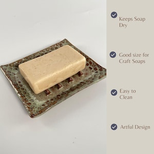 A rectangular Seafoam Green Soap Dish, with a bar of soap. Wording shows Features as follows: Keeps soap dry, Good size for craft soap, Easy to clean, and Artful design.