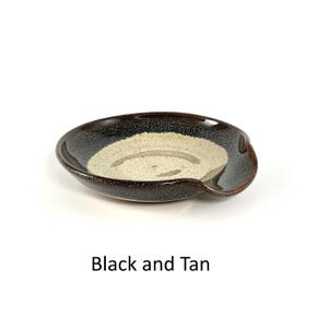 Black and Tan handcrafted spoon rest, shallow round shape with notch for spoon handle, formed on a potter's wheel.