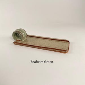 May include: A set of three ceramic mugs with a speckled, matte finish in cream, light grey, and dark grey. Each mug has a minimalist design, ideal for coffee or tea.