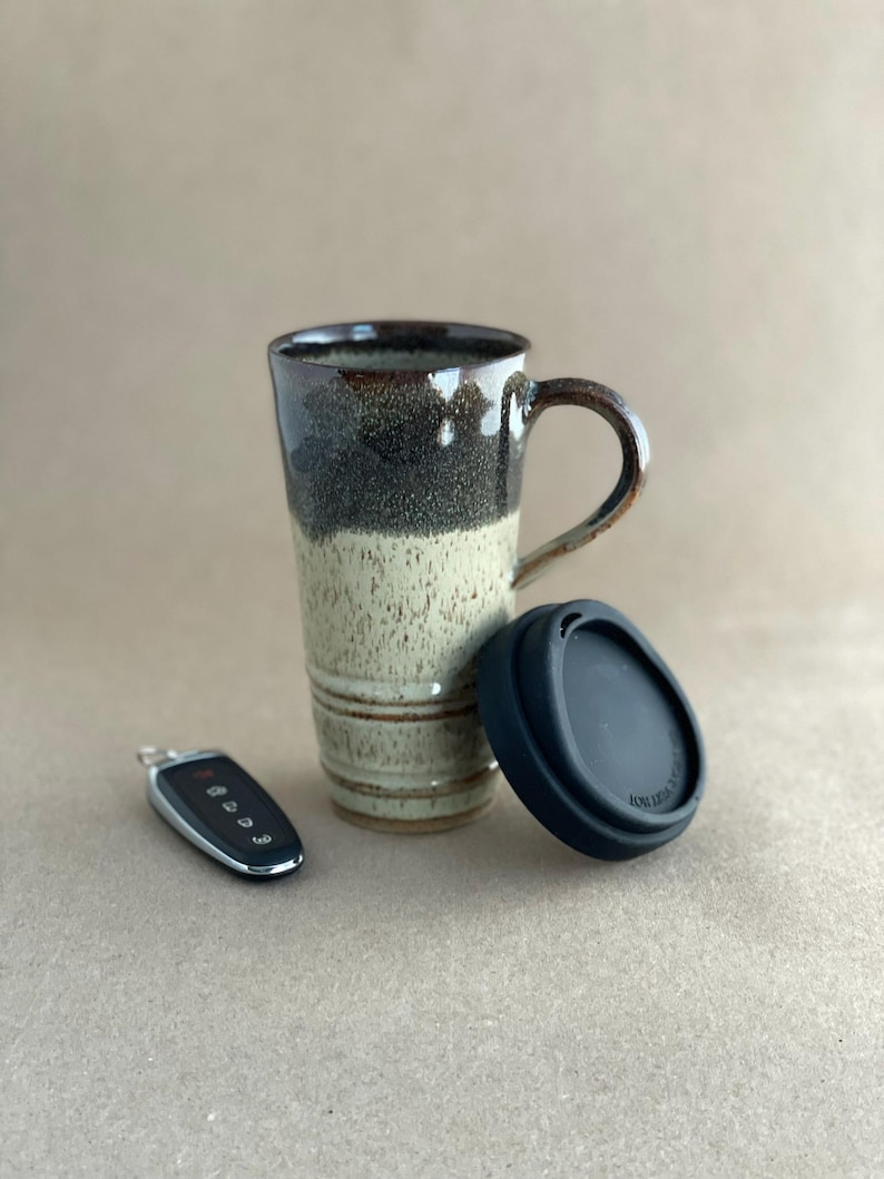 A Black and Tan Travel Mug with Lid and car key