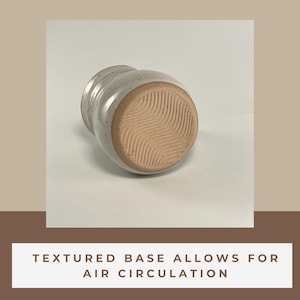 Showing the bottom of a Banded Belly Mug labeled with Textured base allows for air circulation.