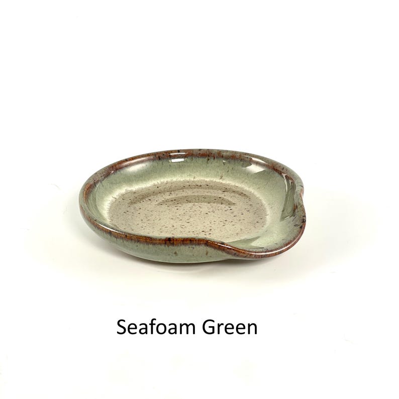 Seafoam Green handcrafted spoon rest, shallow round shape with notch for spoon handle, formed on a potter's wheel.