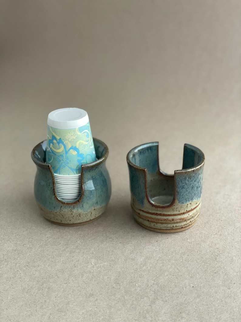 Two Cup Dispensers showing both the Belly Style and the Square Style, one filled with Disposable cups, ready for use and the other showing the slots on both sides to more easily grab the cup.