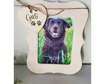 May include: A white wooden picture frame with a heart-shaped tag that says "Gus" with paw prints. The frame has a photo of a black dog inside.