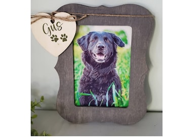 May include: A gray wooden picture frame with a heart-shaped wooden tag that says "Gus" with paw prints. The frame has a photo of a black dog inside.