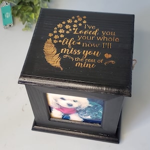 Puede incluir: Caja de madera negra con una inscripci&oacute;n grabada en oro que dice "I've Loved you your whole life now I'll miss you the rest of mine". La caja tiene un peque&ntilde;o marco de fotos con una imagen de un perro blanco.