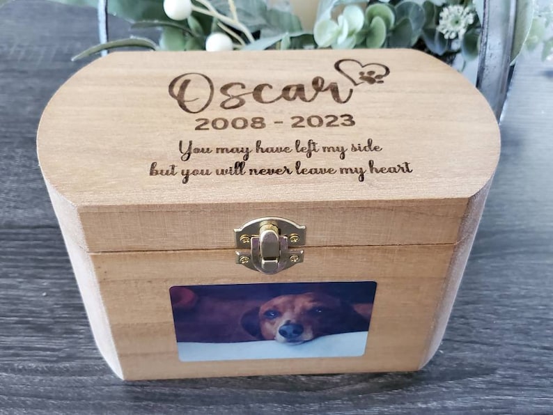 K&ouml;nnte beinhalten: Eine Holzkiste mit einem Scharnierdeckel und einem Messingverschluss. Die Kiste hat einen Fotoeinsatz und ist mit dem Text "Oscar 2008-2023 You may have left my side but you will never leave my heart" graviert.