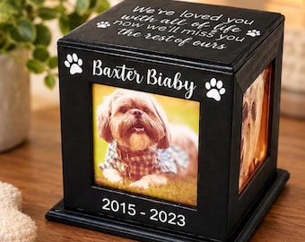 Puede incluir: Una caja conmemorativa de madera negra para mascotas con un marco de fotos en el lateral. La parte superior está grabada con el texto We've loved you with all of life now we'll miss you the rest of ours. El frente muestra el nombre Baxter Biaby, huellas de patas y 2015-2023.
