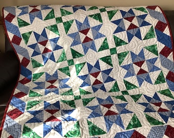 Colourful star Lap quilt in red blue green and white and quilted with swirls.  Use as tabke topper too or as a picnic quilt