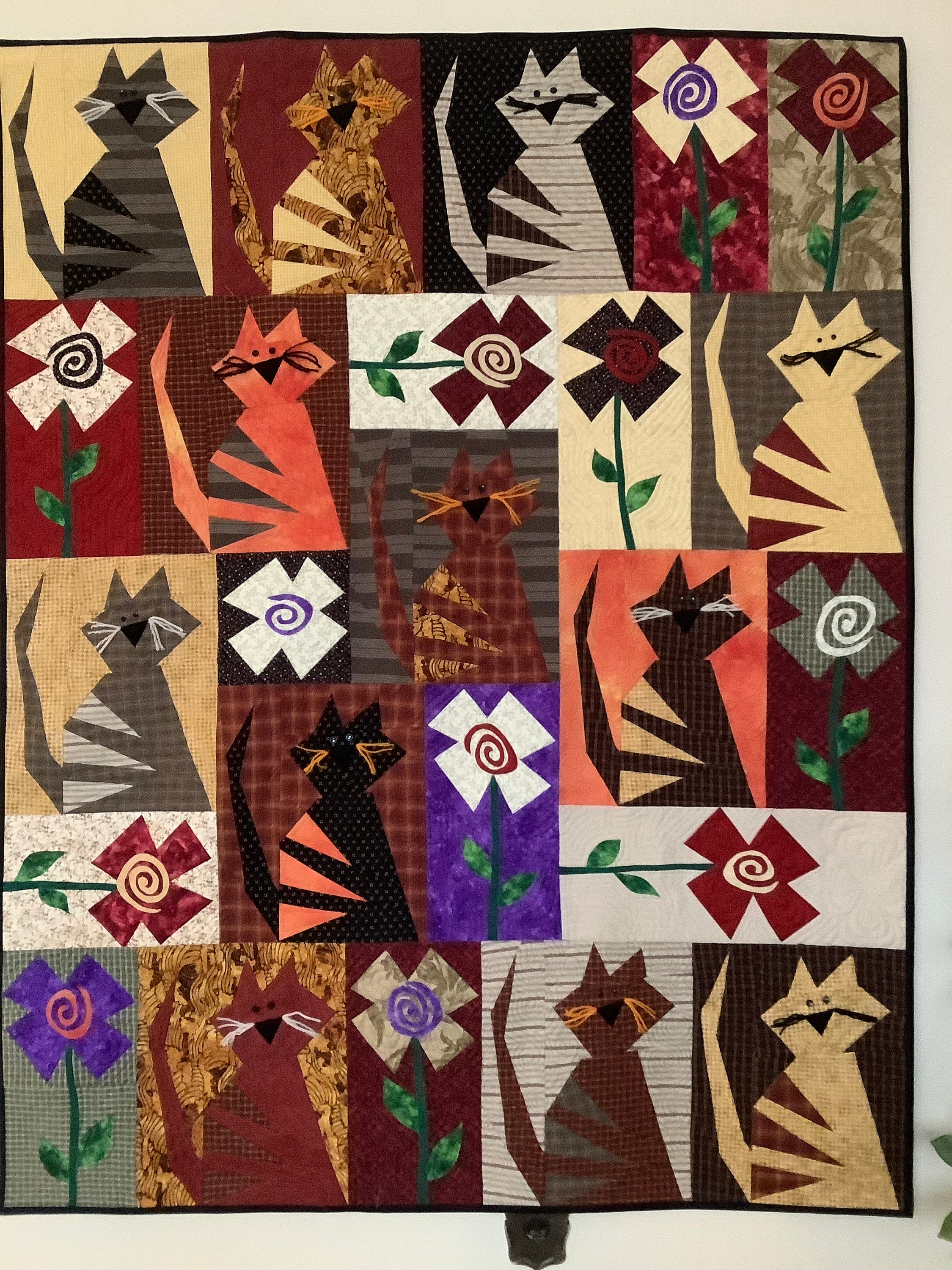 Quilted cat and flower wall hanging or lap quilt, country primitive design in plaids and solids, decorated with wool and buttons, appliqué